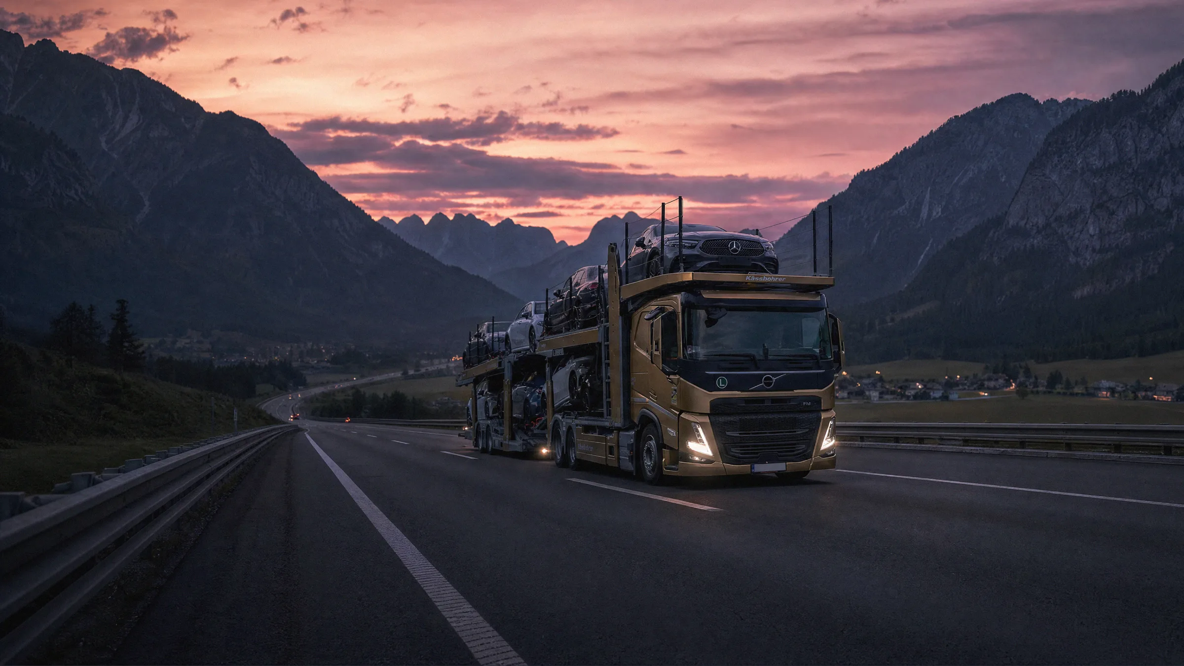 Autotransporter mit mehreren Fahrzeugen auf einer europäischen Gebirgsstraße bei Sonnenuntergang